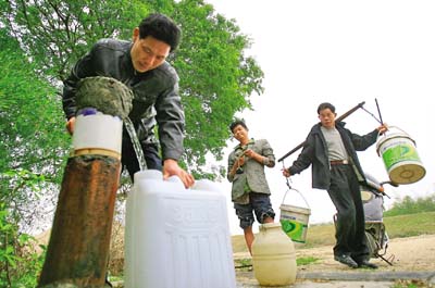 万卢村村民在江边一水井挑水.  记者魏云鹤 摄